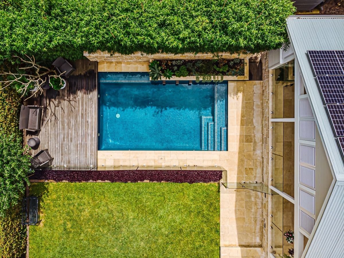 Aerial plan view of the pool, timber deck, lawn and the house roof with solar panels alongside.