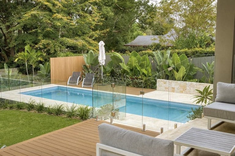 The pool seen from the covered terrace, outdoor lounge seating in the foreground and the deck beyond.