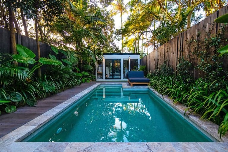The pool straight down its length, travertine coping either side and the studio centred at the end.