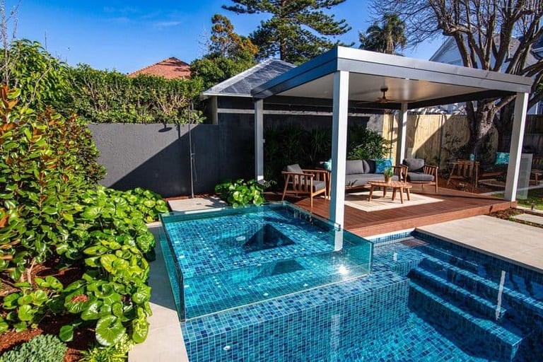 The pool, glass spa and pavilion from the garden, planting in the foreground.