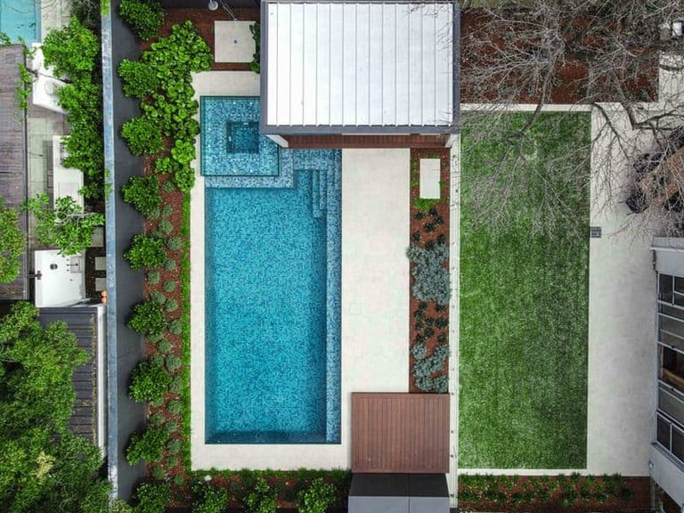 Straight-down aerial of the pool, spa, pavilion roof and the lawn alongside.