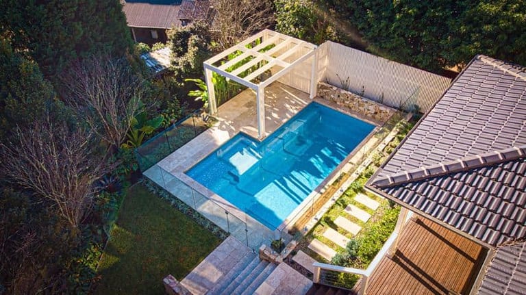 Aerial of the pool, pergola and stepping stones in late afternoon light.