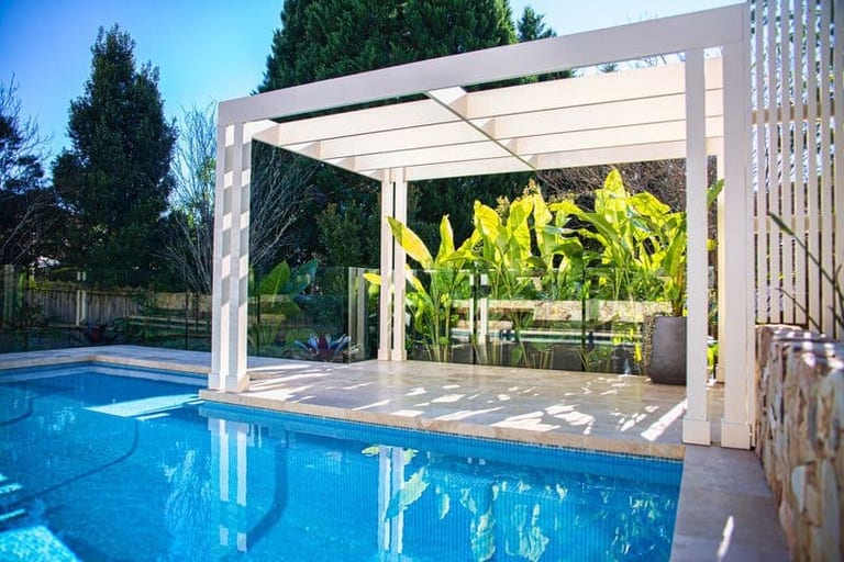 The pool and pergola from the terrace, sandstone retaining wall and stepping stones beyond.
